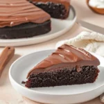 Slice of moist chocolate cake made with cake mix and sour cream, showing rich texture with chocolate frosting.Doctored Chocolate Cake Mix with Sour Cream