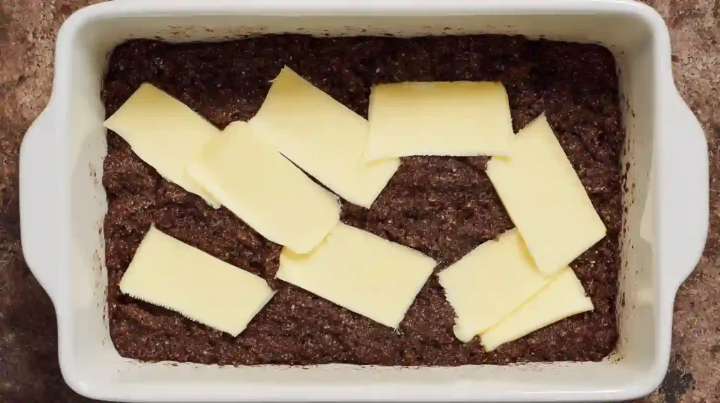 Butter slices layered on chocolate cake mix for Chocolate Dump Cake from Mix, one-pan dessert recipes and easy desserts for families made with the best boxed cake mix recipes