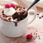 Chocolate Mug Cake from Cake Mix with whipped cream and raspberries in a white ceramic mug