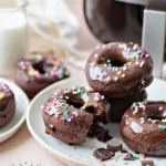 Chocolate donut mug cakes made in an air fryer with glaze and sprinkles on a white plate.Air Fryer Chocolate Donut Mug Cakes photo 01