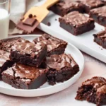 Fudgy chocolate cake mix brownies made from cake mix with crackly tops and chocolate chips on a white plate