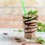Mint Chocolate Cookie Protein Powder shake in glass with straw