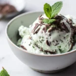 Scoop of white mint chocolate chip ice cream in a bowl