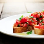 Classic Italian bruschetta recipe served on toasted bread with tomato and basil