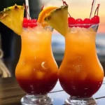 Coral Sunset Slammer Cocktail in a tropical setting