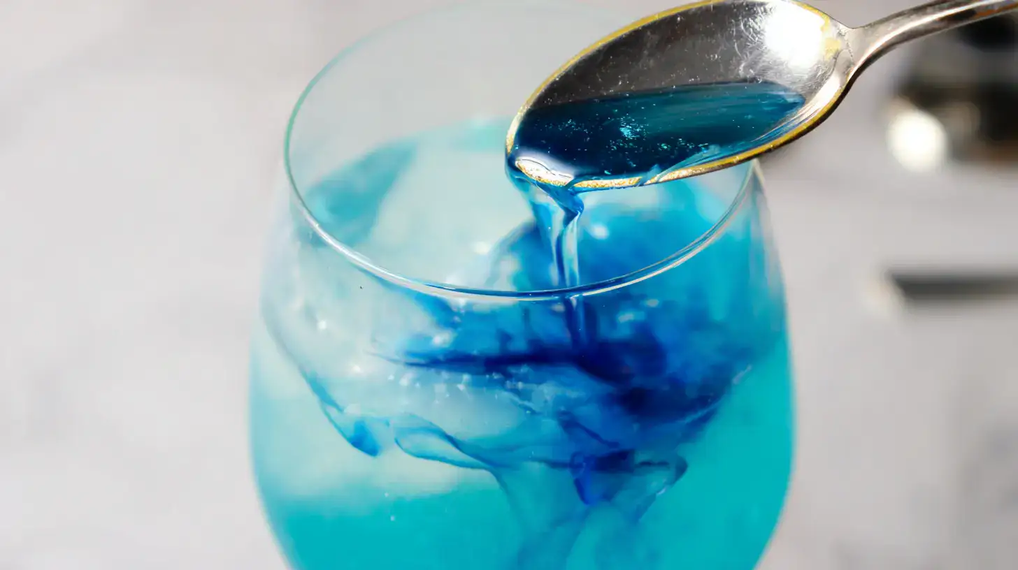 layering-blue-curaçao-swirl. Drizzling blue syrup into mocktail to create galaxy swirl