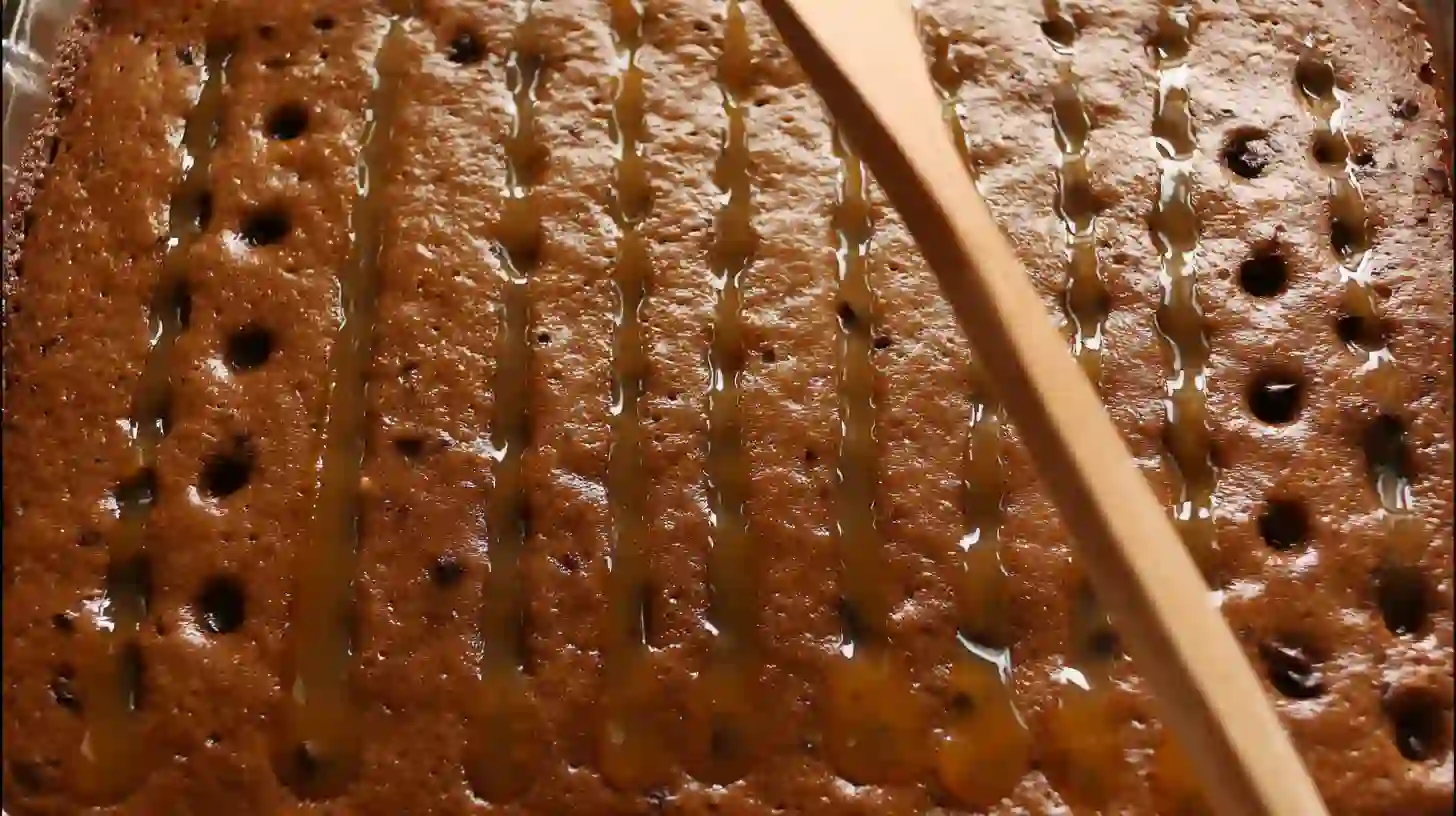 poke-and-soak-german-chocolate-cake-step 4 poking holes in German chocolate poke cake and pouring caramel into them