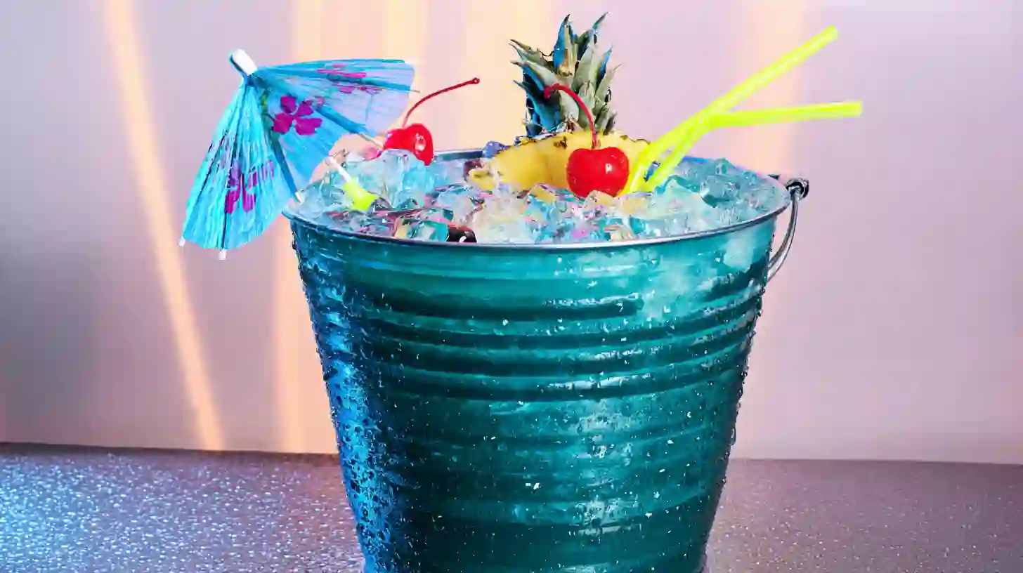 serving-malibu-mermaid-bucket-cocktail Garnished Malibu Mermaid Cocktail with straw and fruit