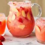 pitcher and glasses of summer strawberry apple punch with ice