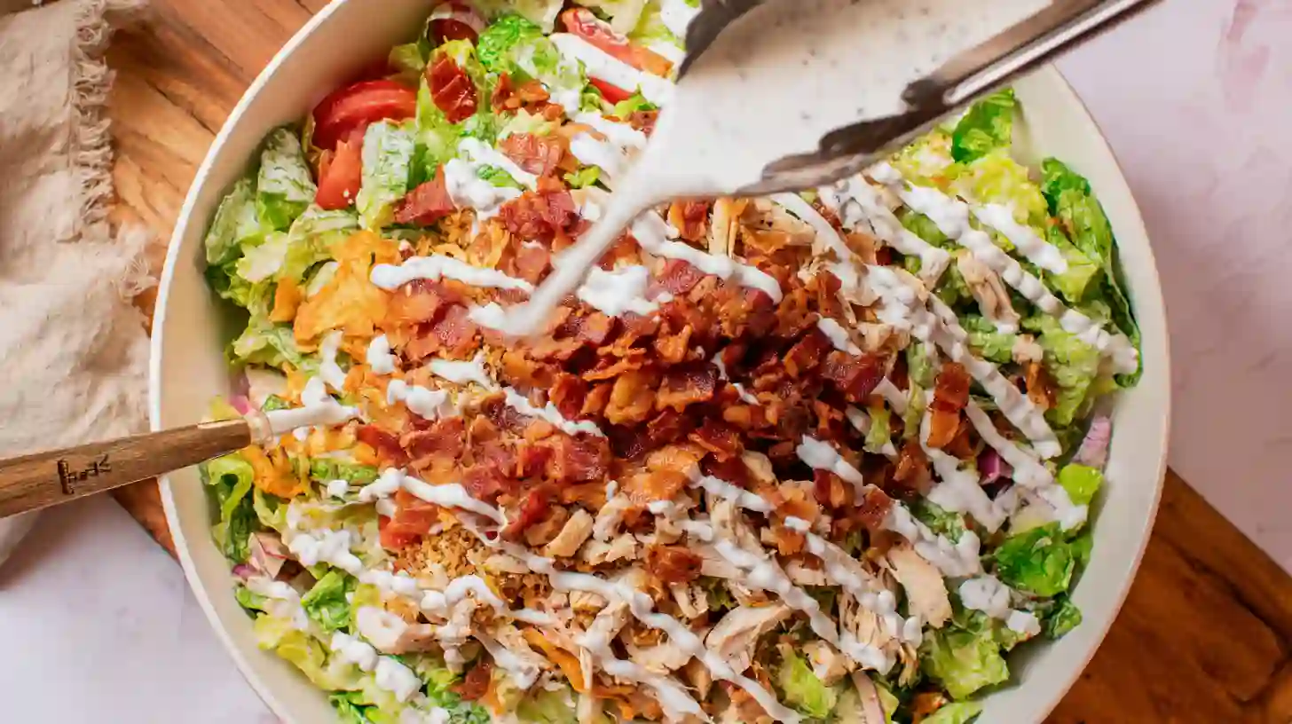tossing-blt-salad-dressing tossing grilled chicken BLT salad with ranch