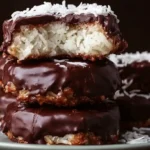 Chocolate Coconut Bars stacked with glossy chocolate topping