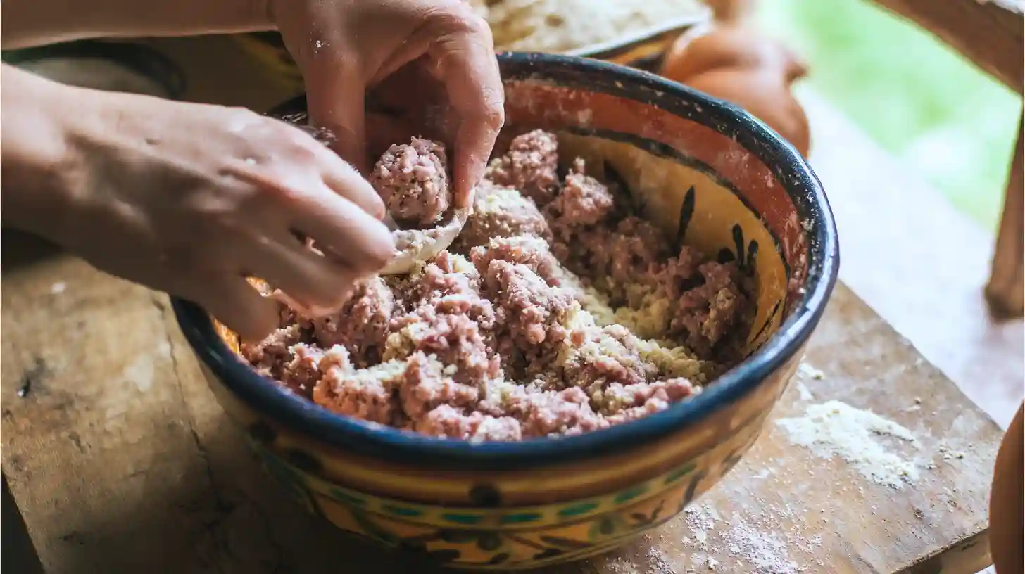 mix-meatballs-caldo-de-albondigas hands mixing beef, onions, and masa harina for albóndigas
