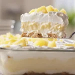 Serving a slice of chilled No-Bake Pineapple Heaven Cheesecake Dessert from dish