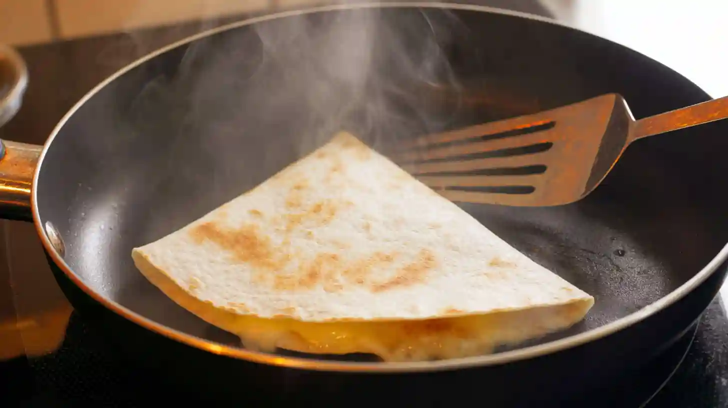step-6-toasting-quesadilla-non-stick-skillet Quesadilla toasting in a non-stick skillet with melted butter.non-stick skillet for burgers