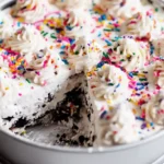 Decorating No-Bake Funfetti Oreo Icebox Cake recipe with whipped cream and sprinkles, one of the best easy desserts for kids to make