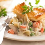 Healthy Chicken Pot Pie Pasta serving on plate – golden puff pastry over creamy chicken pasta bake, perfect healthy comfort food dinner for families.
