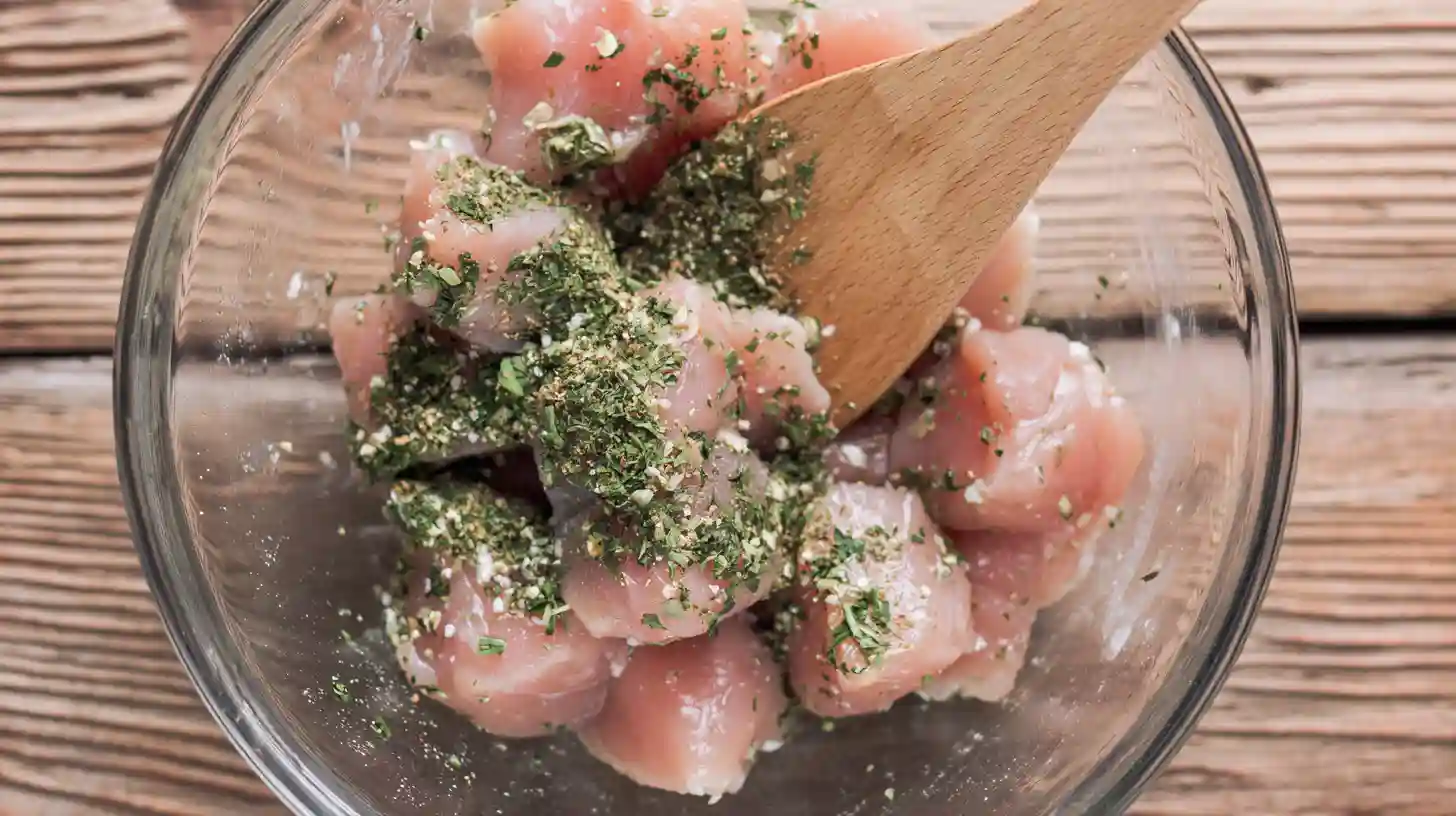 lemon-garlic-chicken-bites-step1-season High protein chicken bites for weight loss seasoned with oregano, basil, parsley, salt, and pepper in a bowl