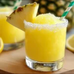 Straining pineapple lemon drop cocktail into sugared glass – easy summer cocktails with fresh juice