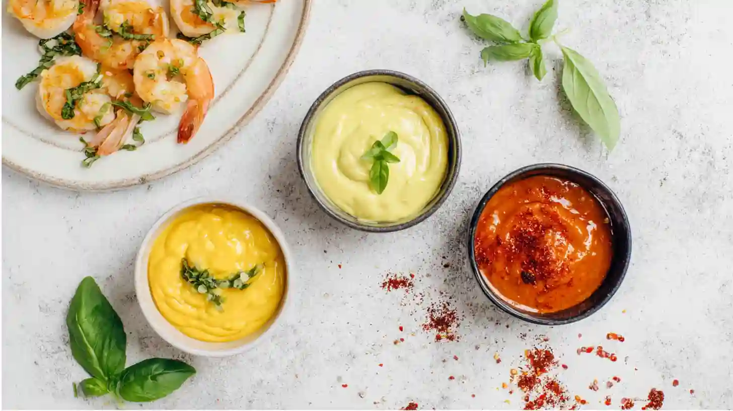 shrimp-corn-sauce-pairings-lemon-basil-aioli-cajun-remoulade-honey-garlic-chili Lemon basil aioli, spicy Cajun remoulade, and honey garlic chili glaze for garlic butter baked shrimp and corn