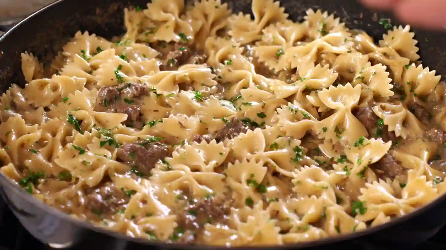 step-5-creamy-beef-and-bowtie-pasta-final-mix Toss bowtie pasta in creamy beef sauce for easy creamy beef and bowtie pasta – creamy ground beef pasta skillet, quick and cheap family meals, high protein dinner ideas