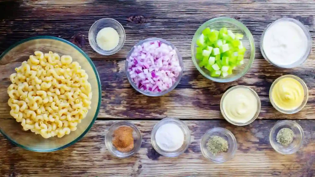 Macaroni salad ingredients with mayo, vegetables, and seasoning for an easy macaroni salad recipe