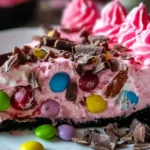 Pink Paradise No-Bake MM Snickers Cheesecake with Oreo crust, M&Ms, and whipped cream topping