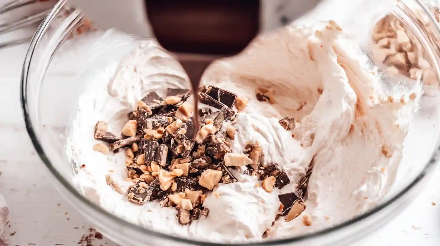 pink-paradise-no-bake-snickers-mms-cheesecake-step3-whip-filling Cream cheese dessert recipes — whipping filling with chocolate and Snickers for premium no-bake cheesecake