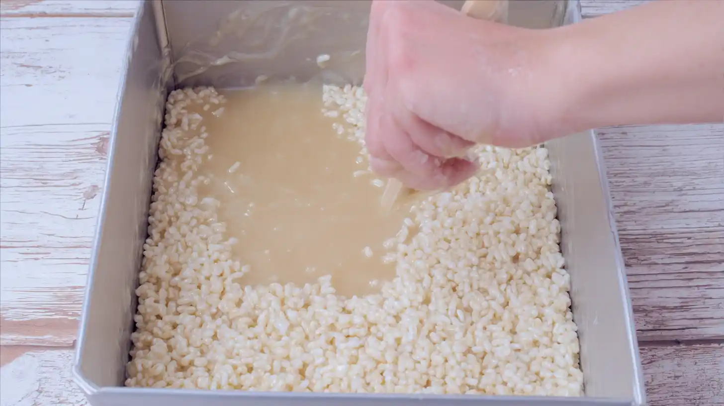 Easy Rice Krispie Millionaires Bars Recipe step 1 – melting marshmallows and butter with rice krispies for indulgent no bake desserts
