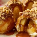 Melt-in-your-mouth apple caramel bombs made with biscuit dough, filled with warm apple filling, topped with caramel sauce and crushed peanuts.