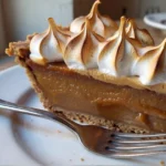 Close-up slice of homemade Butterscotch Heaven Pie with graham cracker crust and toasted meringue topping served on a white plate, best creamy butterscotch dessert recipe