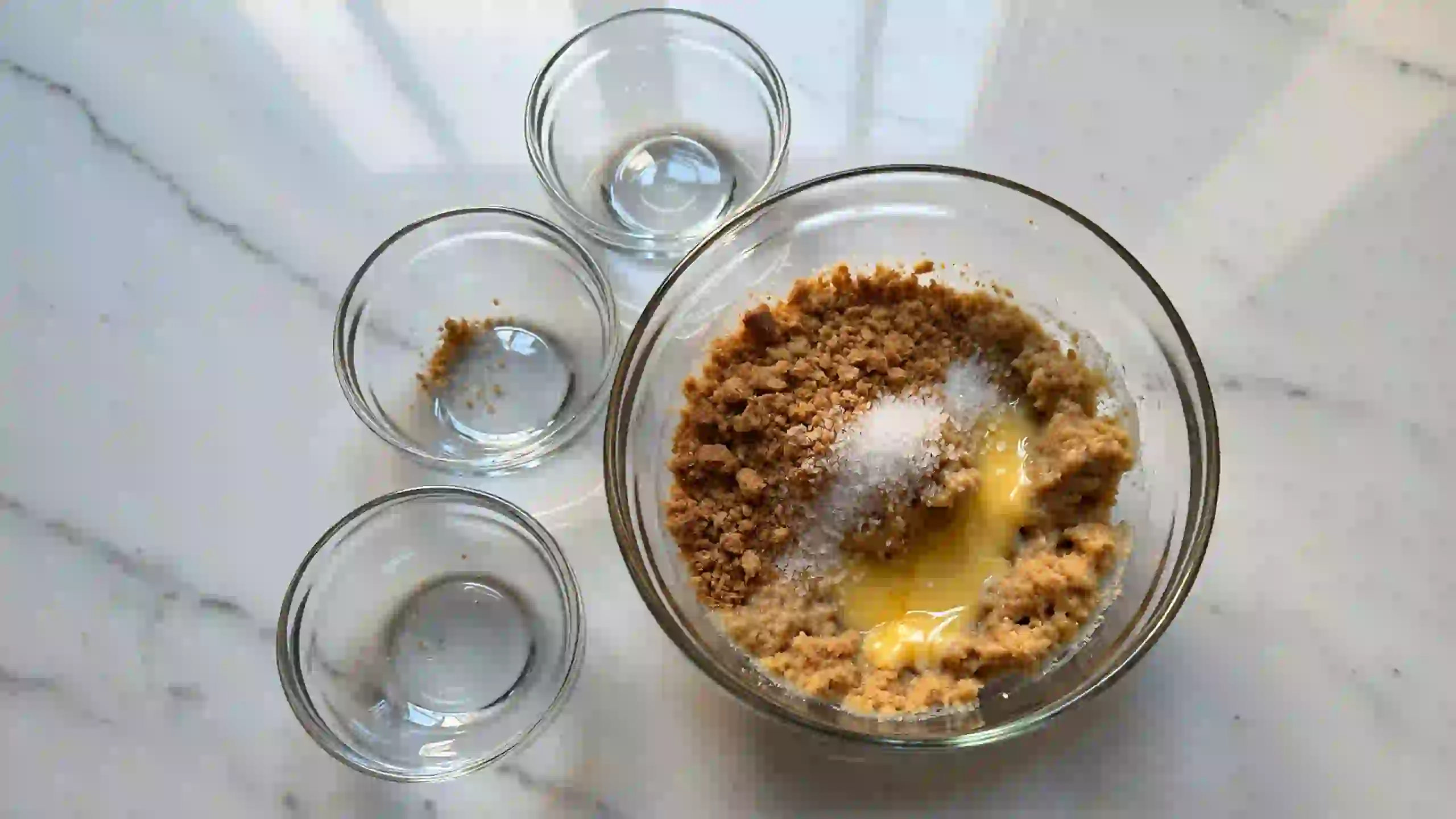 How to make graham cracker crust for butterscotch pie – mix of graham crumbs, melted butter, and sugar on white marble for homemade dessert base