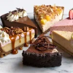 Six assorted Easy No-Bake Cream Pies slices on marble: chocolate pie with whipped cream, strawberry cream pie with fresh berries, banana cream pie with vanilla pudding, pineapple pie with coconut, mocha pie with coffee and cocoa, and pecan cream pie with caramel drizzle.