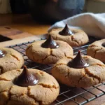 4-ingredient peanut butter kiss cookies with Hershey’s chocolate on white plate, easy holiday cookie recipe photo on marble background