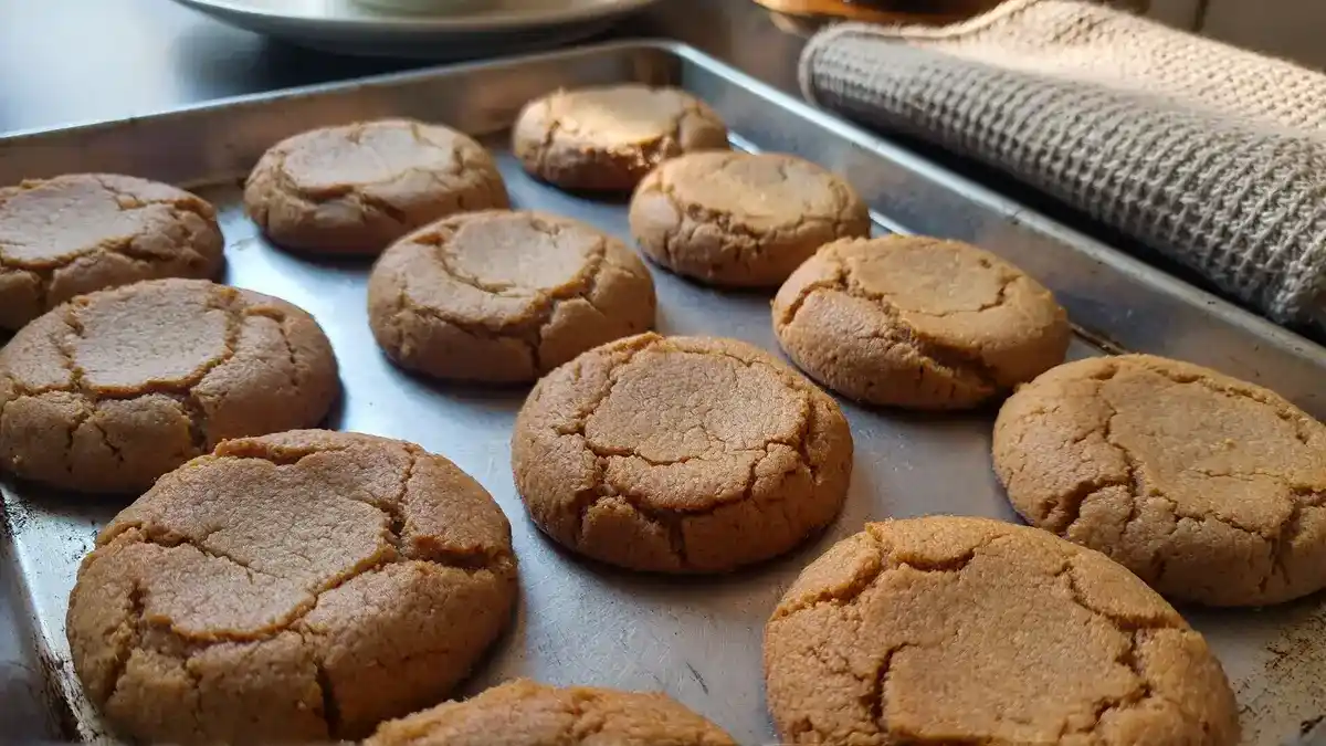 Freshly baked soft peanut butter cookies with cracked tops on a baking sheet — easy holiday cookie recipe without mixer