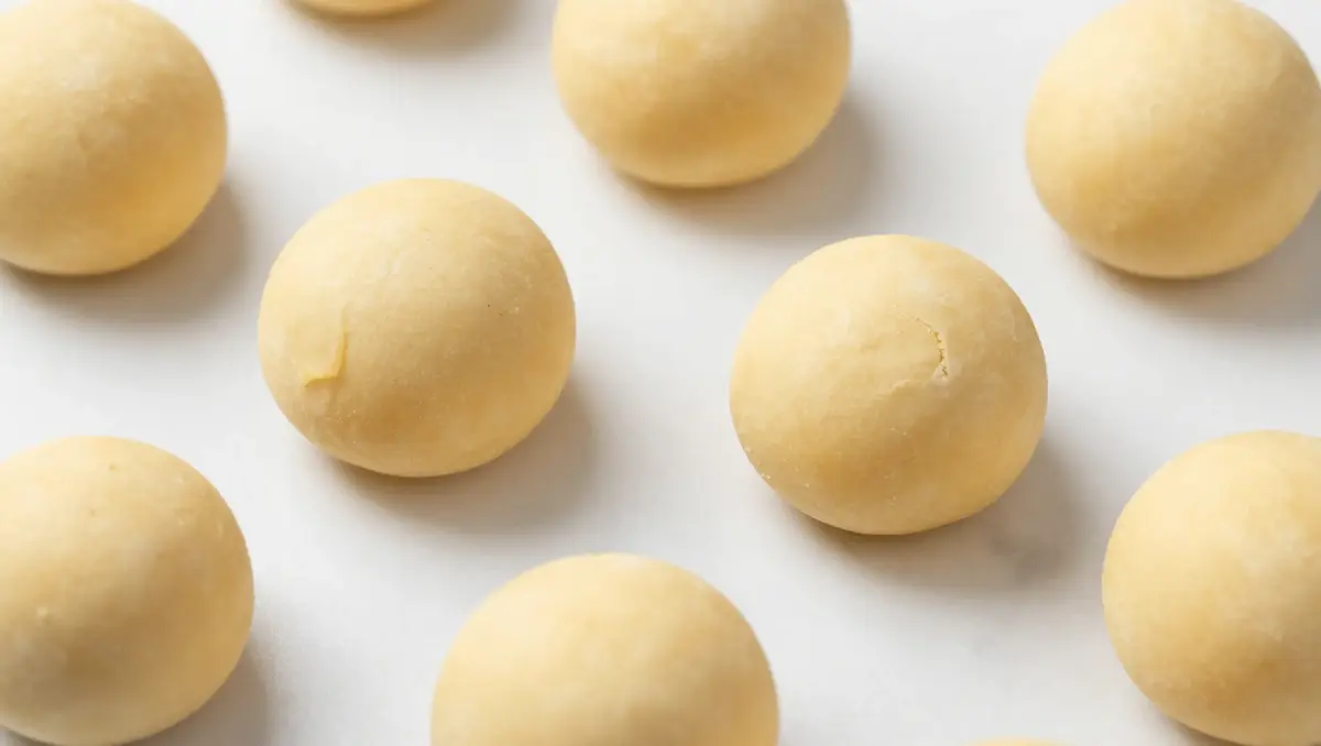 Stuffed cheesecake cookie dough balls sealed and ready to bake on white marble – cinnamon donut cookie dessert preparation step